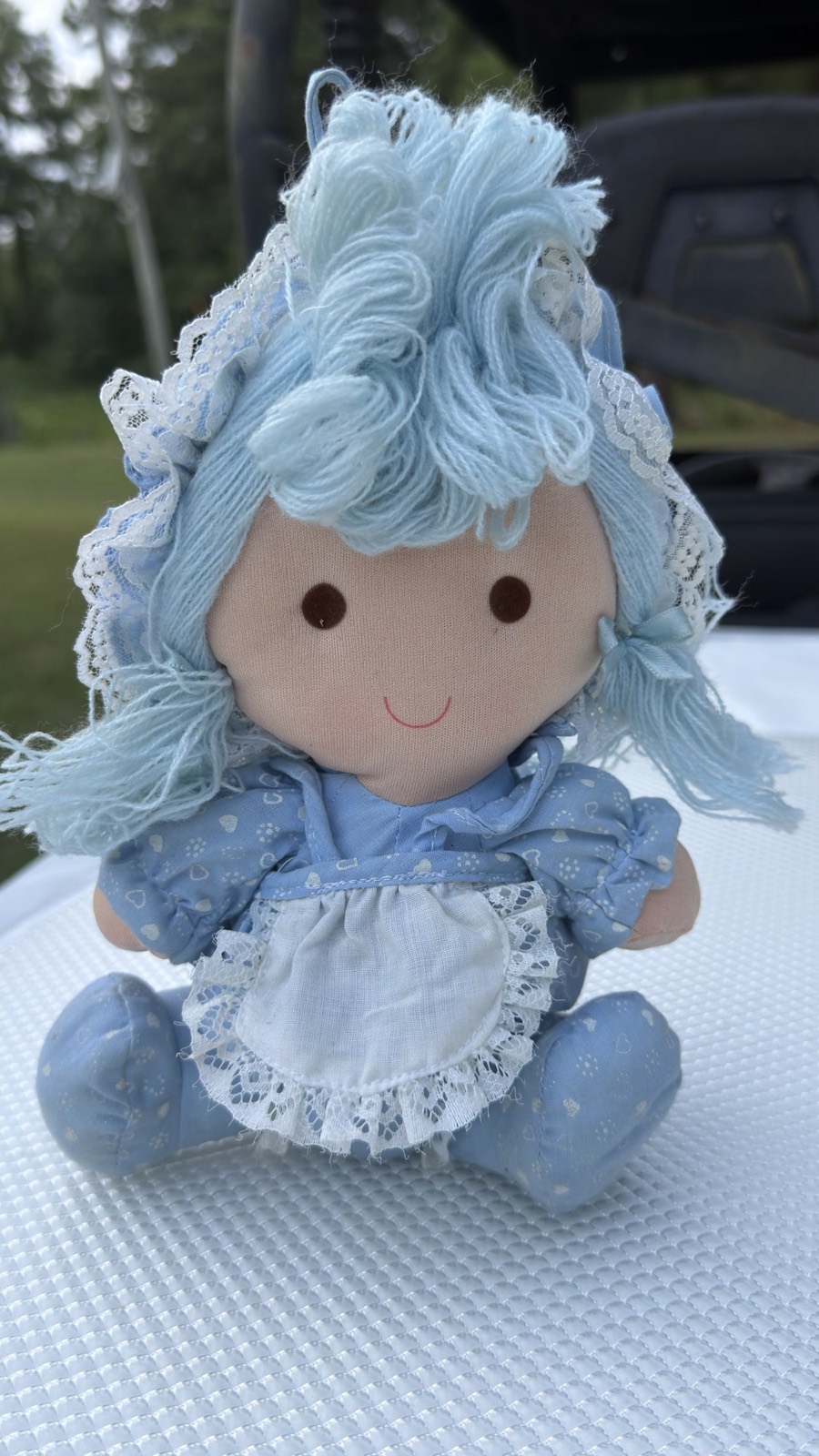 1982 Dan Dee Imports rag doll, seated front view in blue heart-and-flower print dress, white eyelet pinafore and lace bonnet