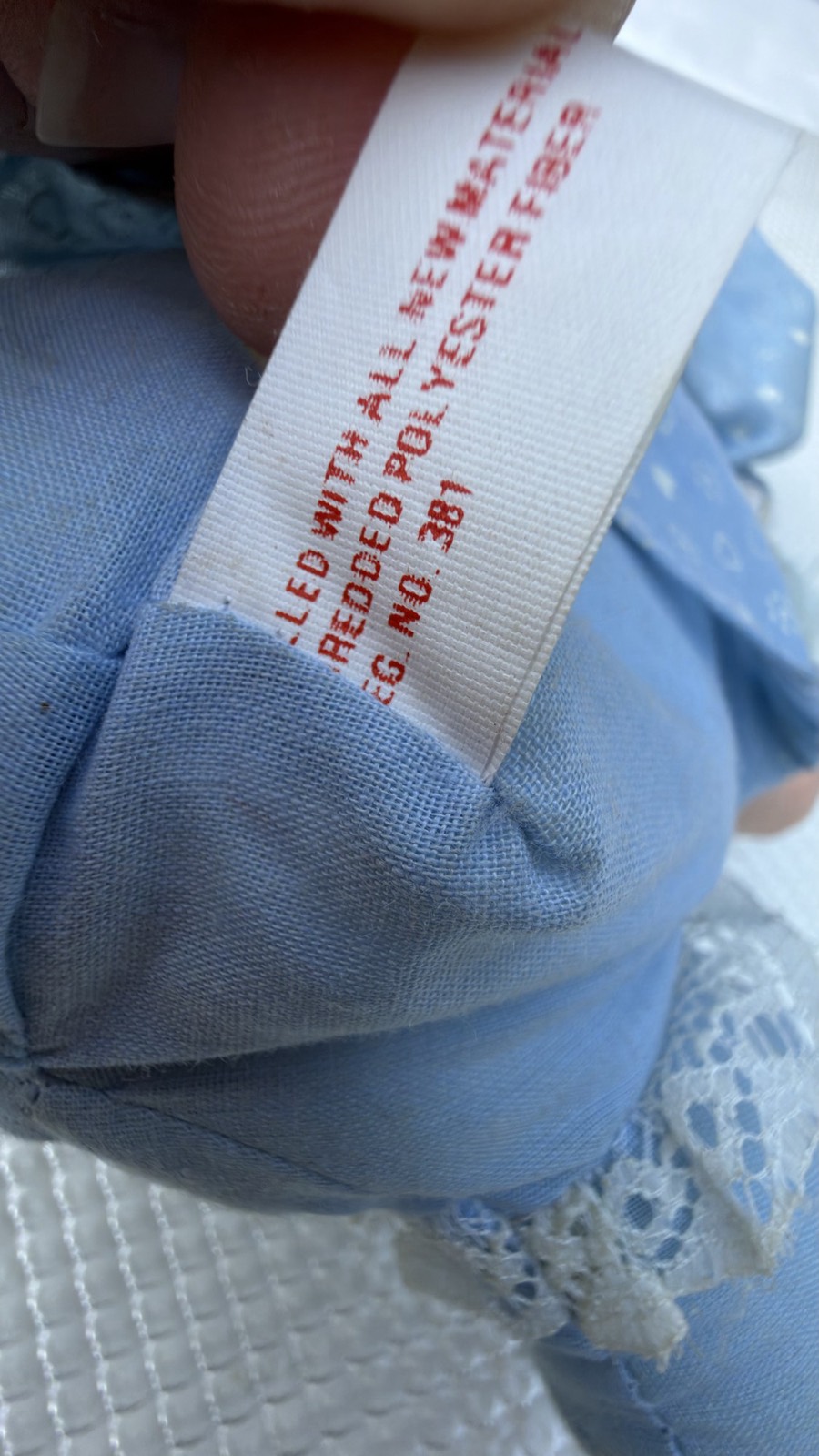 Partial close-up of the rag doll's original sewn-in fabric tag