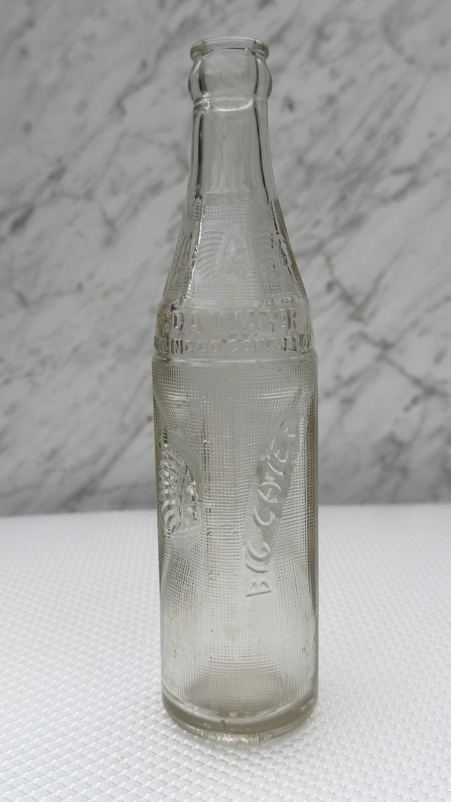 Big Chief soda water bottle standing upright, clear embossed glass with waffle texture
