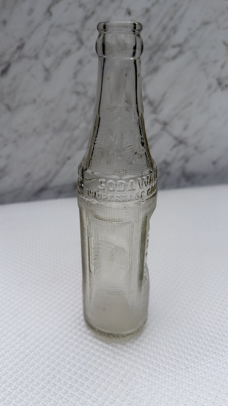 Embossed Indian chief head in full headdress on the body panel of the bottle