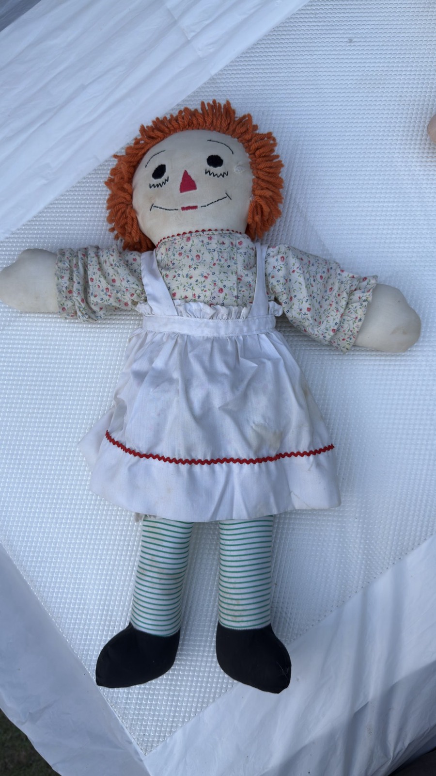 Large handmade Raggedy Ann doll, full body straight-on — floral dress, white pinafore with red rickrack, green-and-white striped legs