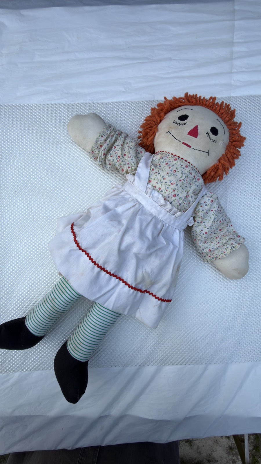 Closer angled view of the large Raggedy Ann showing the hand-embroidered face and black button eyes