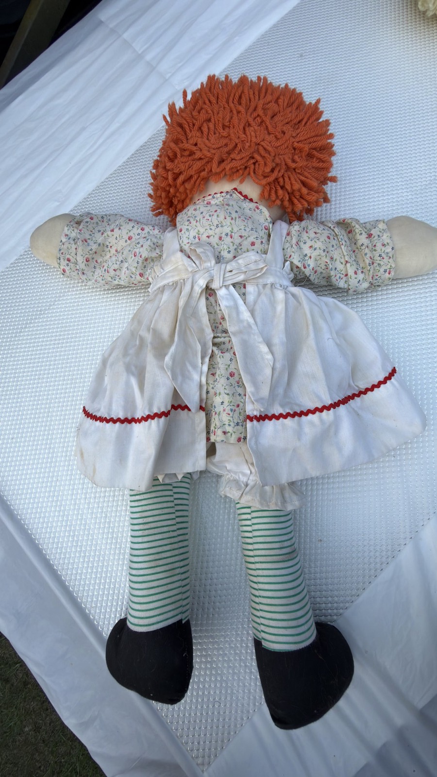 Full back view of the large handmade Raggedy Ann doll showing the yarn hair and pinafore ties