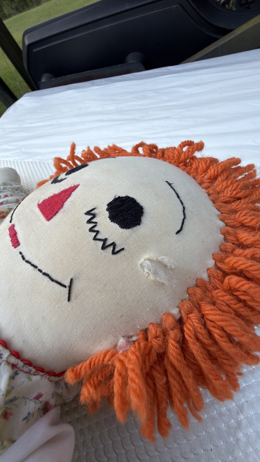 Condition detail: worn thin spot with slight rub-through on the doll's right cheek
