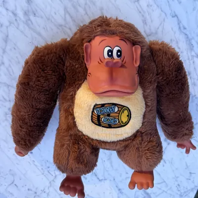 Vintage 18-inch Etone Nintendo Donkey Kong plush laid flat, full front view showing the tan chest and barrel graphic
