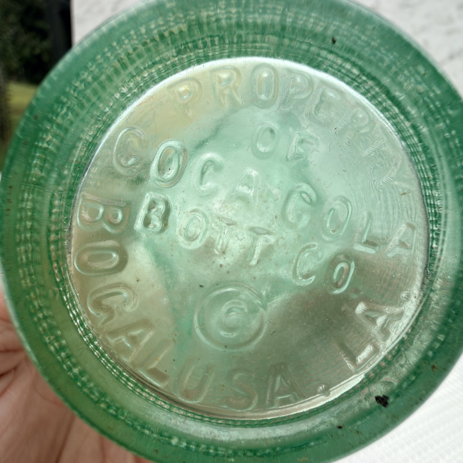 Base of the green soda bottle embossed PROPERTY OF COCA-COLA BOTT CO, BOGALUSA, LA.