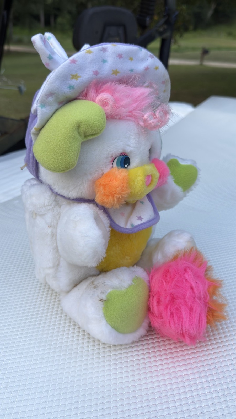 Side profile of the 1986 Baby Cribsy Popple showing the bonnet and pink-and-orange pom tail