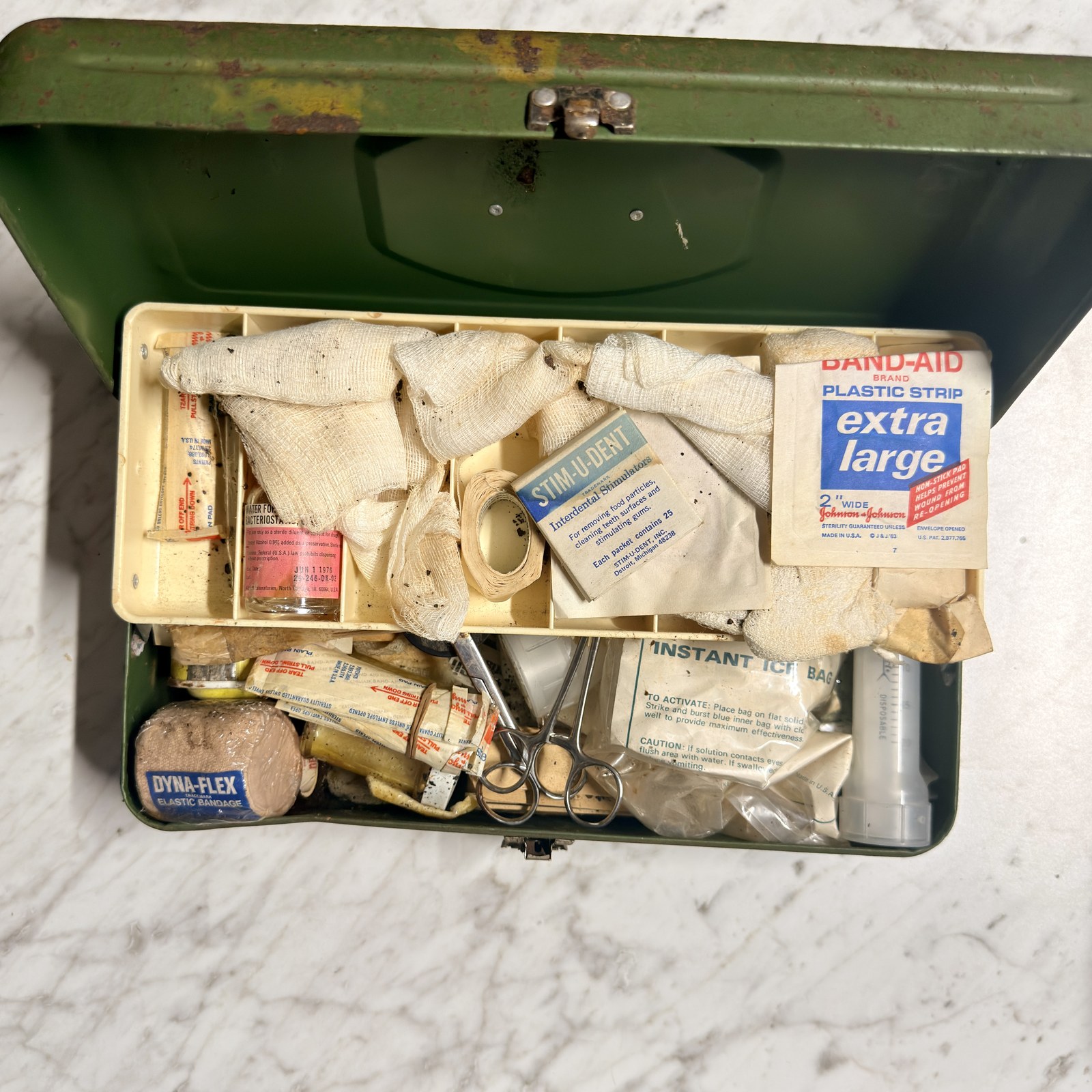 Open first-aid kit showing the removable tray and the contents as found